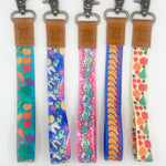 Five colorful keychains with patterned straps on a white background
