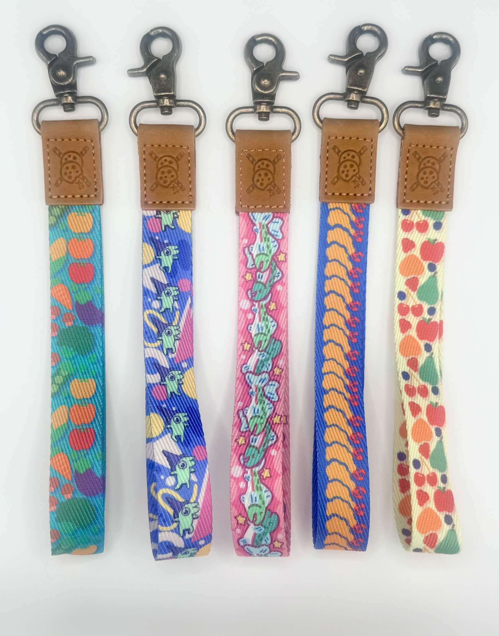 Five colorful keychains with patterned straps on a white background